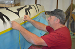 Geoff Workman applies Seward logo to Wave's kayak.